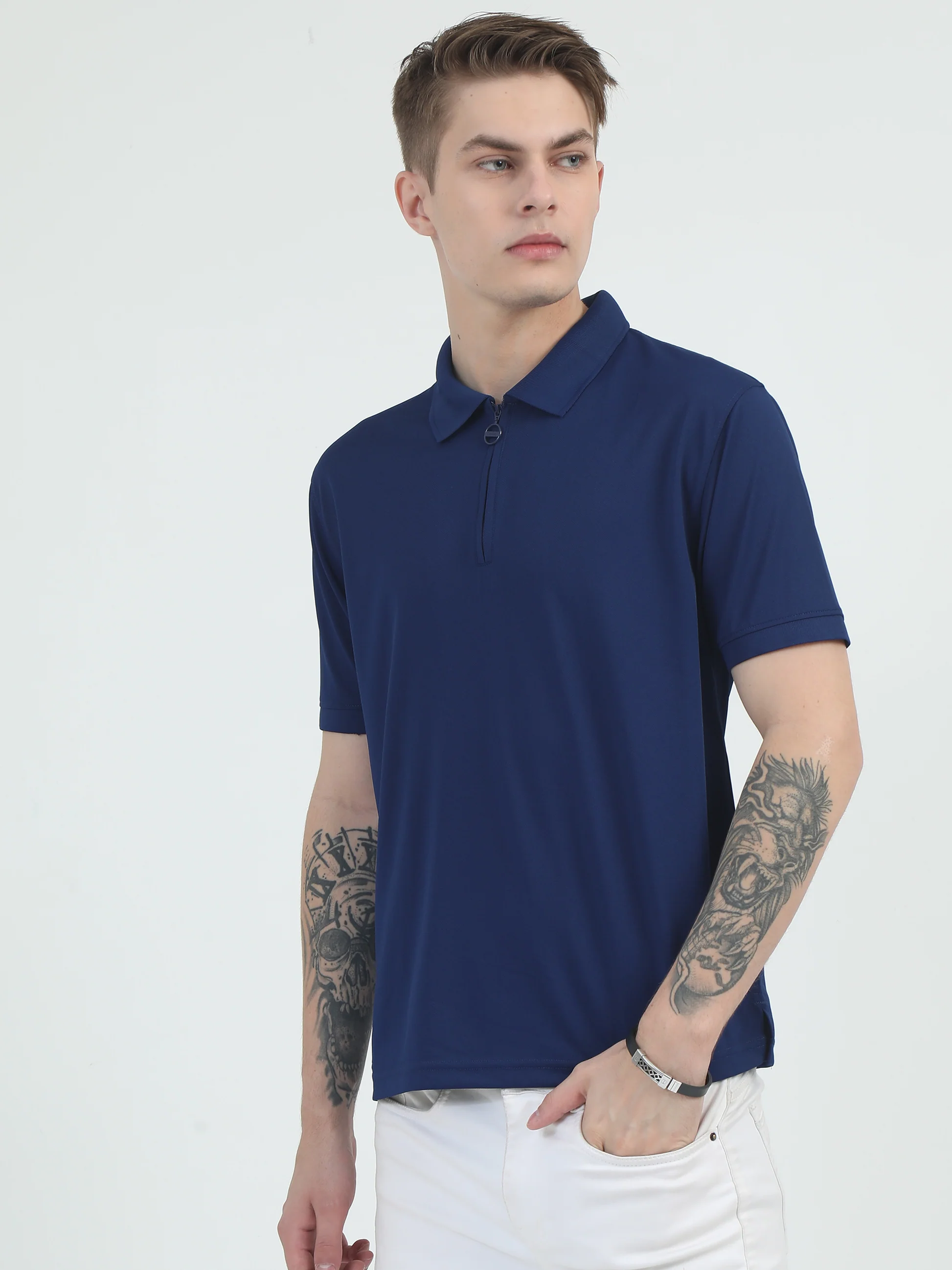 Male model wearing navy blue blazer and striped tie standing outdoor with autumn greenery background